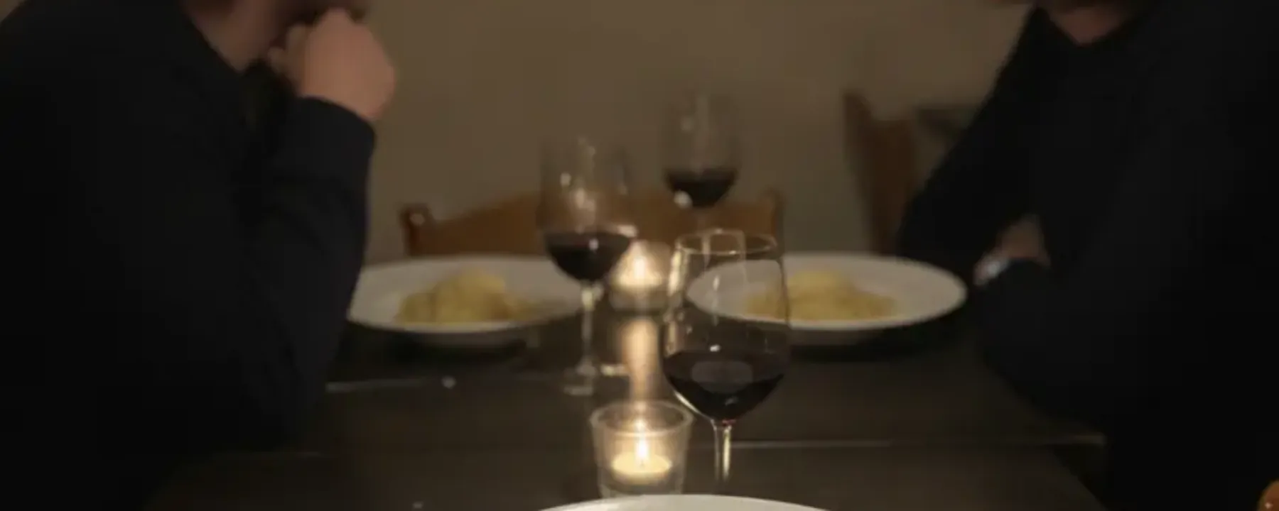 Zwei Gäste sitzen von hinten am gedeckten Tisch im Gastraum von Punto DiVino