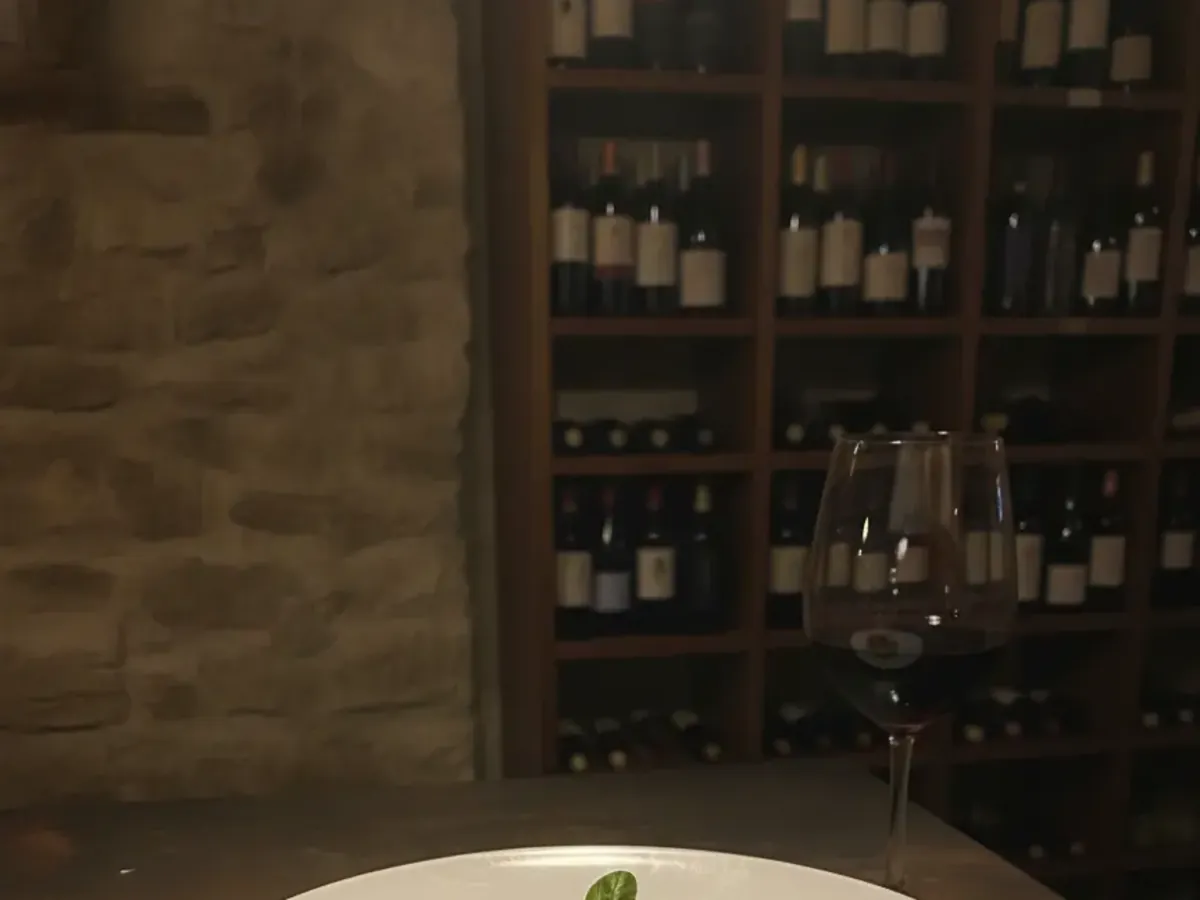 Weinregal an der Kellerwand von Punto DiVino, dicht gefüllt mit italienischen Flaschen